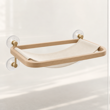 Halo Window Perch with rounded light-oak frame, cream canvas sling, and clear suction cups